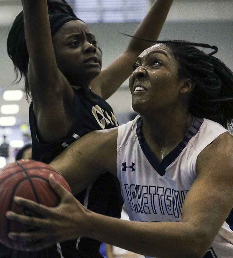 Fayetteville’s Jasmine Franklin (right) drives to the basket against Little Rock Central’s Mariyah Green during Thursday’s game at the Class 7A girls state tournament at North Little Rock High School. See more photos at arkansasonline.com/galleries 