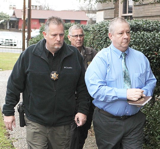 The Sentinel-Record/Richard Rasmussen MURDER SUSPECT: Garland County Circuit Court bailiffs R.J. Dunn, left, and Ronnie Dunn, back, escort Eric Allen Reid, 57, who is charged with two counts of capital murder for the shooting deaths of his wife and daughter, into the Garland County Court House Thursday morning for the first day of testimony in his trial.