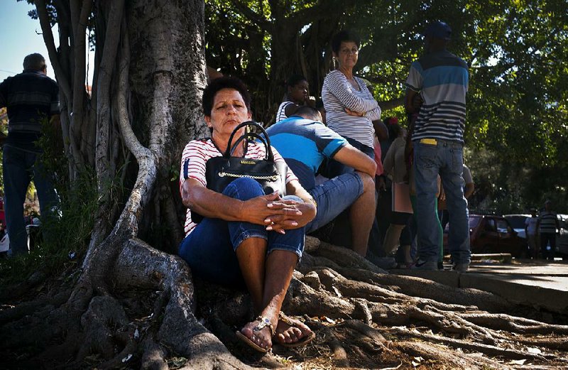 People wait to file visa applications Friday outside the Colombian Embassy in Havana, hoping to travel from Cuba to Bogota and access the U.S. Embassy there. 