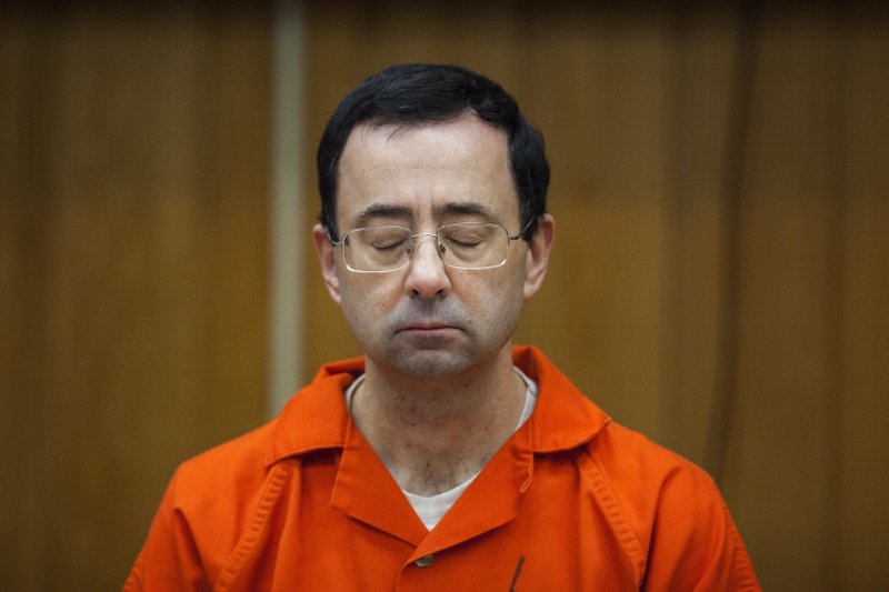 FILE - In this Feb. 5, 2018, file photo, Larry Nassar listens during his sentencing at Eaton County Circuit Court in Charlotte, Mich. Right in the midst of the Pyeongchang Games, with hardly enough time for Larry Nassar to settle into the prison cell where he'll be spending the rest of his life, we got another report detailing horrific abuse and shameful cover-ups within one of the most high-profile summer sports. (Cory Morse/The Grand Rapids Press via AP, File)