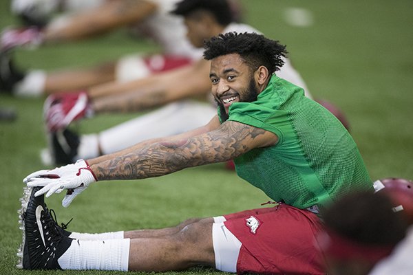 Arkansas receiver Jared Cornelius stretches prior to practice Thursday, March 1, 2018, in Fayetteville. 