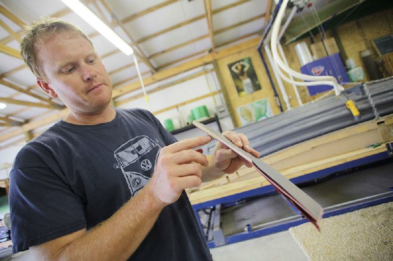 Louis Shaw, co-owner of Two Brothers Canoes in Rogers, points out the layers of material used to make the body of a canoe. A new material, called T-Formex, has allowed two Arkansas canoe makers to resume production. 