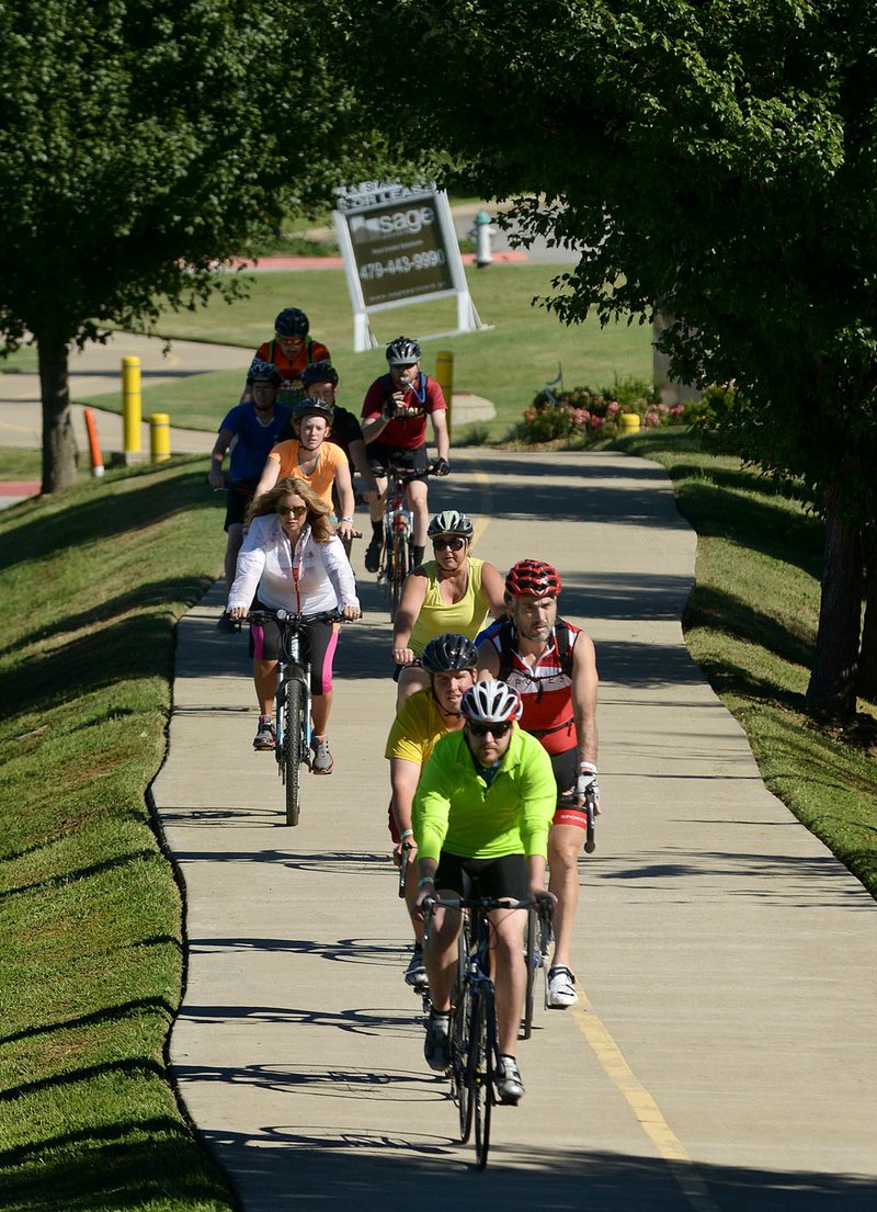 Riders make their way through Rogers during a Square to Square Bicycle Fun Ride on the Razorback Regional Greenway.