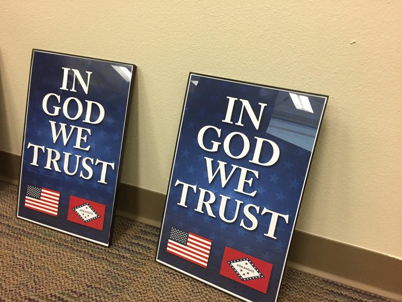 Northwest Arkansas Democrat-Gazette/DAVE PEROZEK Two of the framed "In God we trust" posters presented to Bentonville School Board members at their Feb. 19 meeting are seen here. State Rep. Jim Dotson, R-Bentonville, and Ray Brust, a representative of American Legion Post 77, presented the posters to the board. They said nearly 900 more are being donated to Bentonville schools for display in classrooms and libraries.