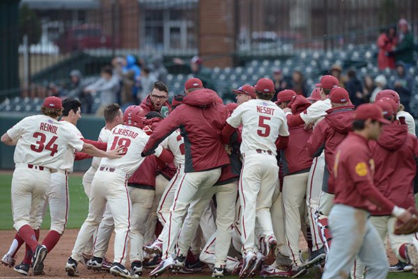 Arkansas players celebrate following a game-winning hit by Dominic Fletcher during a game against Southern Cal on Sunday, March 4, 2018, in Fayetteville. 