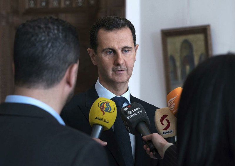 President Bashar Assad speaks with reporters Sunday in Damascus, Syria.
