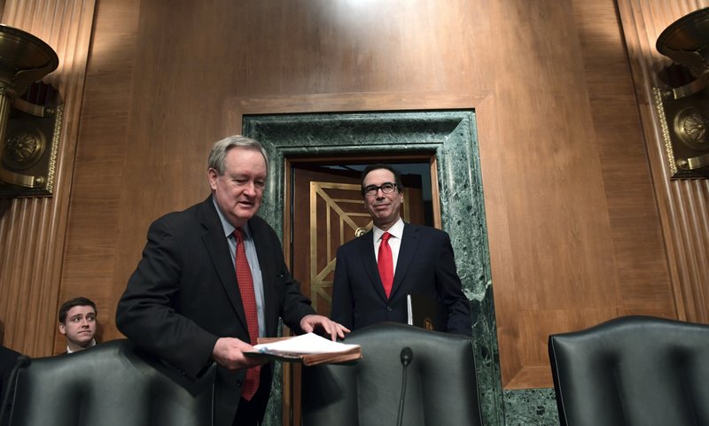 In this Jan. 30 file photo, Senate Banking Committee Chairman Sen. Mike Crapo, R-Idaho, second from left, arrives with Treasury Secretary Steven Mnuchin, right, at the Senate Banking Committee on Capitol Hill in Washington. Ten years after the financial crisis rocked the nation’s economy, the Senate is poised to pass legislation that would roll back some of the safeguards Congress put into place to prevent a relapse. The Senate bill emerged from lengthy negotiations between Crapo and Democratic members on the committee. The ranking Democrat, Sen. Sherrod Brown of Ohio, said the changes go too far and he walked away. (AP Photo/Susan Walsh, File)