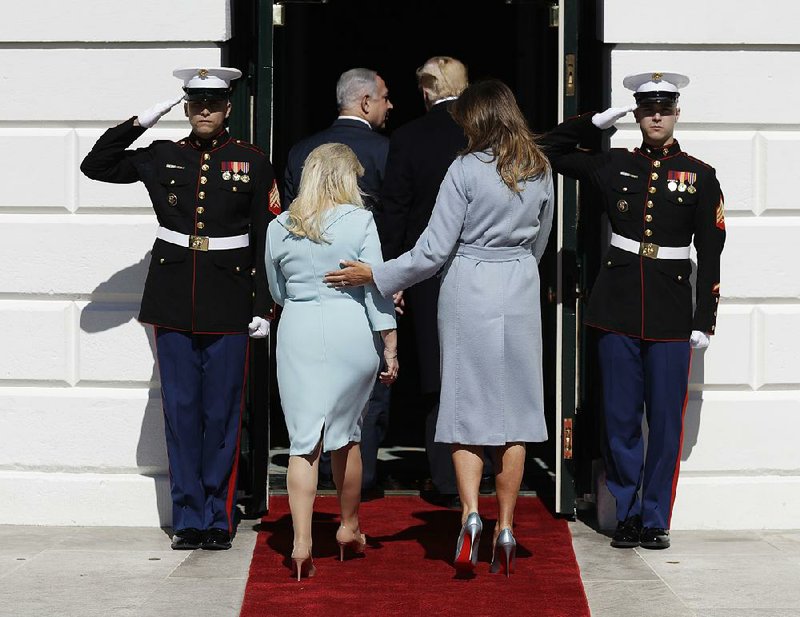 President Donald Trump and fi rst lady Melania Trump greet Israeli Prime Minister Benjamin Netanyahu and his wife Sara as they arrive at the White House on Monday in Washington.