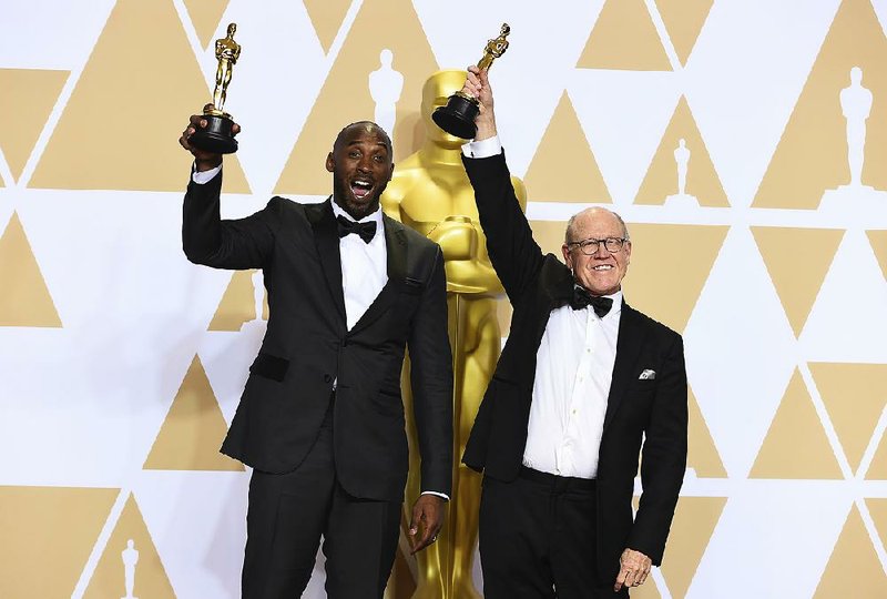 Kobe Bryant (left) and Glen Kean hold up the Oscars they won Sunday night for the best animated short film Dear Basketball at the Dolby Theatre in Los Angeles.