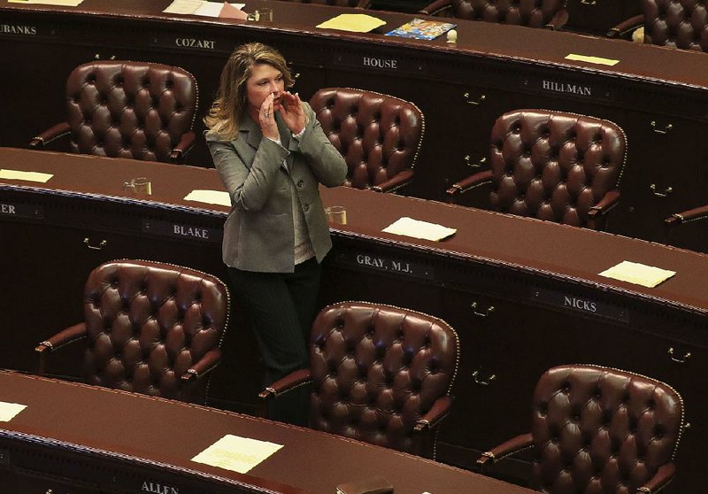 Rep. Michelle Gray, R-Melbourne, tries to get the attention of a colleague Monday afternoon before the House begins its session.