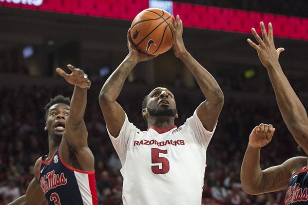 Arkansas forward Arlando Cook (5) attempts a shot as Ole Miss guard Terence Davis (3) and forward Bruce Stevens (12) defend during a game Saturday, Jan. 20, 2018, in Fayetteville. 