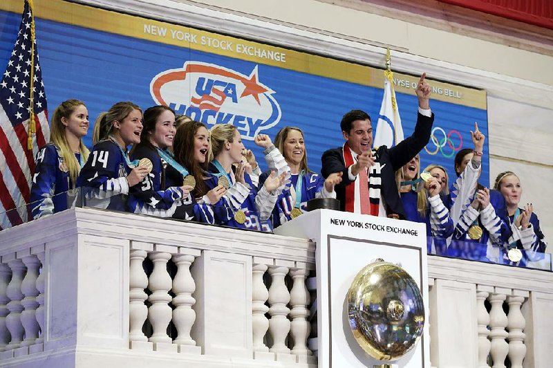 Members of the U.S. Olympic gold medal women’s hockey team ring the New York Stock Exchange opening bell Tuesday, accompanied by exchange President Tom Farley. U.S. stocks eked out a small gain Tuesday after a choppy session as investors worried about mixed signals on whether President Donald Trump will follow through on raising tariffs.  