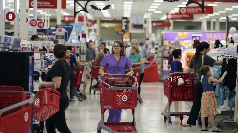 Customers shop in a Target store last fall in Dallas. Target increased its minimum hourly wage last fall to $11, and the CEO reiterated Tuesday that the wage will rise to $15 by the end of 2020. 