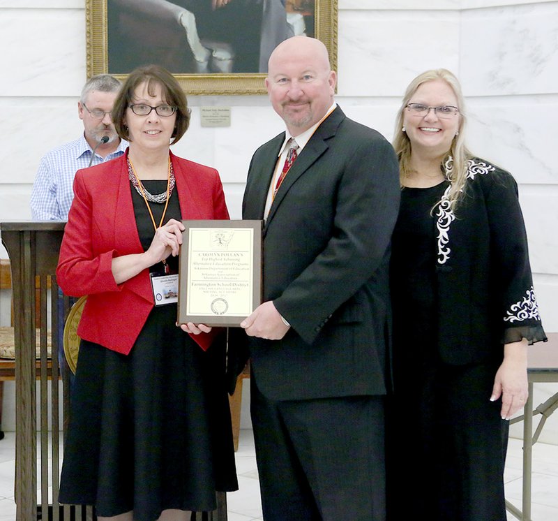 COURTESY PHOTO Glenda Bolinger, facilitator for Farmington High School's alternative education program, and Jon Purifoy, school principal, accept an award from the Arkansas Department of Education and Arkansas Alternative Education. The ceremony was held at the state Capitol in Little Rock. Lori Lamb, director of the state's Alternative Education, stands to the right.