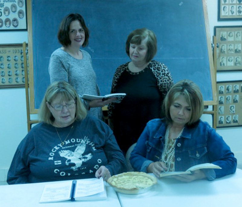 Westside Eagle Observer/SUSAN HOLLAND Jen Thurlo and Lavon Stark (standing), Nancy Amos and Charlene Newell, members of Northwest Arkansas Cattlewomen, browse through cookbooks looking for new pie recipes as their annual benefit pie auction draws near. The event is scheduled for 6:30 p.m. Tuesday, March 14, at the Maysville Community Building.