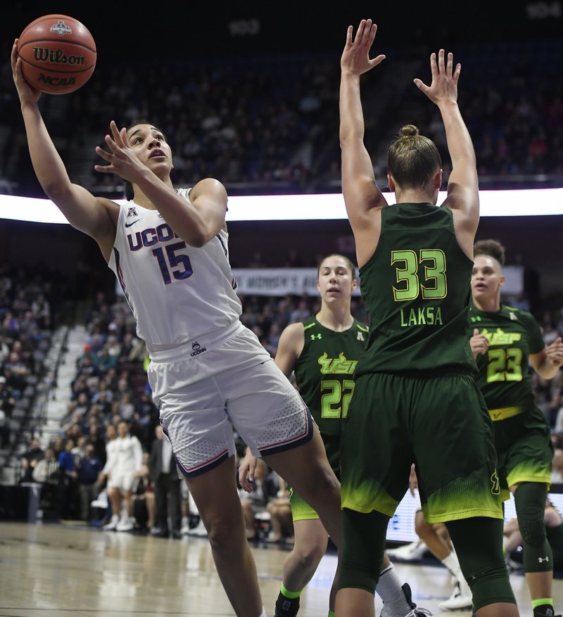 Connecticut's Gabby Williams (15), cuts through the defense of South Florida's Laia Flores (22), Kitija Laksa (33) and Tamara Henshaw (23) for a basket during the first half of an NCAA college basketball game in the American Athletic Conference tournament finals at Mohegan Sun Arena, Tuesday, March 6, 2018, in Uncasville, Conn. (AP Photo/Jessica Hill)