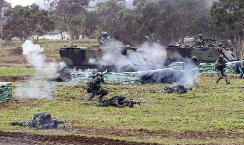 FILE - In this Jan. 30, 2018, file photo, Taiwanese soldiers move during a military exercises to show its determination to defend itself from Chinese threats, in Hualien County, eastern Taiwan. Taiwan will look to its domestic arms industry as well as foreign suppliers to respond to China's continuing military buildup, but has no interest in engaging in an arms race with its cross-strait rival, the defense ministry said Tuesday, March 6, 2018. (AP Photo/Chiang Ying-ying, File)