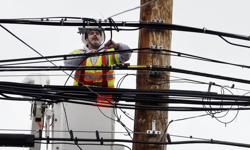 A utility worker attaches wires on a power pole, Tuesday, March 6, 2018, in Watertown, Mass. Utilities are racing to restore power to tens of thousands of customers in the Northeast still without electricity after last week's storm as another nor'easter threatens the hard-hit area with heavy, wet snow, high winds, and more outages. 