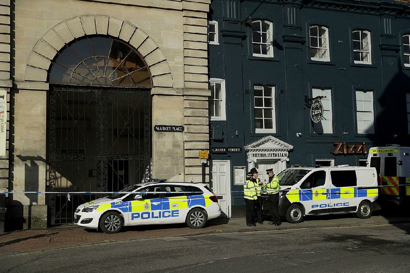 Police officers stand Wednesday in a cordoned-off area outside a restaurant in Salisbury, England, near where ex-spy Sergei Skripal and his daughter were found unconscious. 