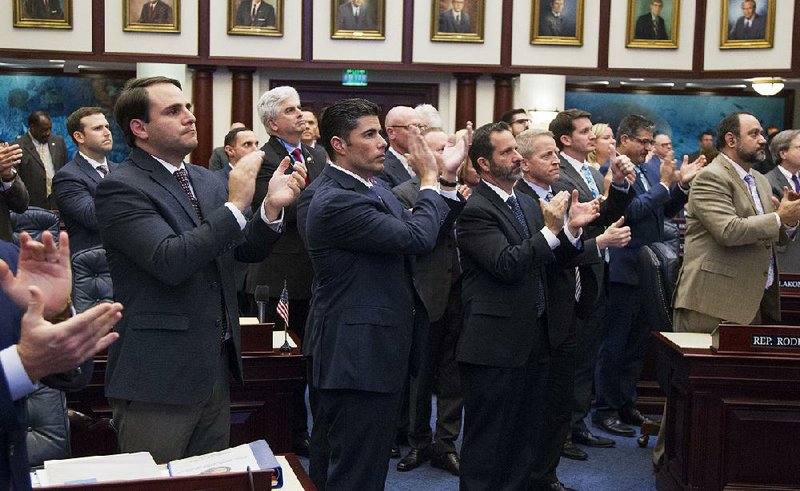 House sponsor Jose Oliva (second from left) is joined by fellow Florida state representatives Wednesday in applauding Andrew Pollack, father of 18-year-old Meadow Pollack, after passing the school-safety bill. Meadow Pollack was among the victims in the Feb. 14 shooting at Marjory Stoneman Douglas High School.  
