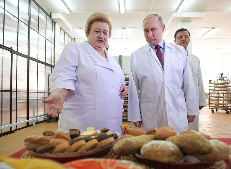 Russian President Vladimir Putin checks out bread and confectionery during a Wednesday visit to a factory in Samara, Russia. 