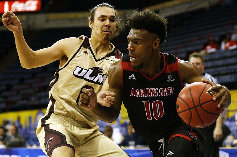 Arkansas State guard Grantham Gillard (10) dribbles round Louisiana-Monroe guard Brandon Newman during the second half of the Red Wolves’ 76-54 loss Wednesday at the Sun Belt Conference Tournament in New Orleans.  