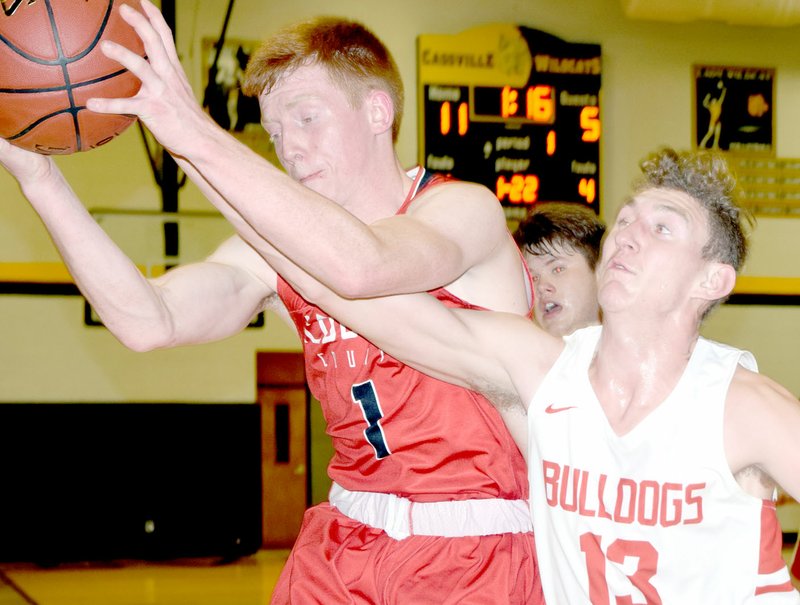 RICK PECK/SPECIAL TO MCDONALD COUNTY PRESS McDonald County's Blake Gravette takes a rebound away form Carl Junction's Will Bebee during the Mustangs' 58-41 loss on March 1 in the district semifinals at Cassville High School.