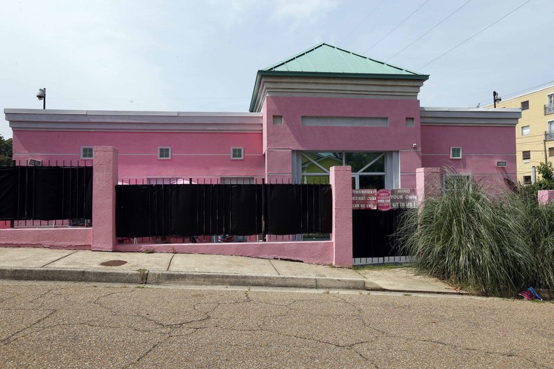 In this June 30, 2015, file photo, razor grass and pro-choice signs limit the view of patients entering the Jackson Women's Health Organization clinic in Jackson, Miss. The facility is currently Mississippi's only abortion clinic. Abortion law experts say House Bill 1510, which passed the Mississippi Senate Tuesday, March 7, 2018, and is one House vote away from the desk of a governor eager to sign it, is an invitation to the Supreme Court to allow states to begin restricting abortion earlier in pregnancy. The law that passed the Senate would ban most abortions after 15 weeks. 