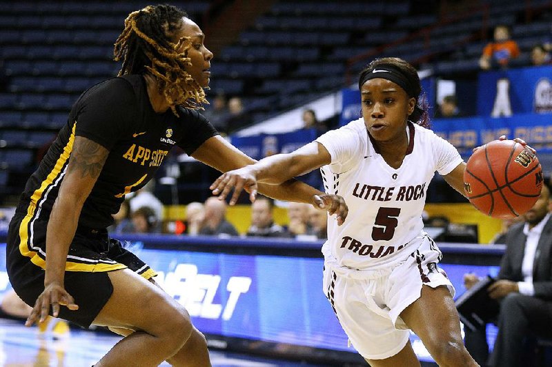 In the file photo UALR guard Tori Lasker (5) drives against Appalachian State forward Maya Calder (1) during first half action in the quarterfinal round of the Sunbelt Tournament in New Orleans, March 8, 2018. 