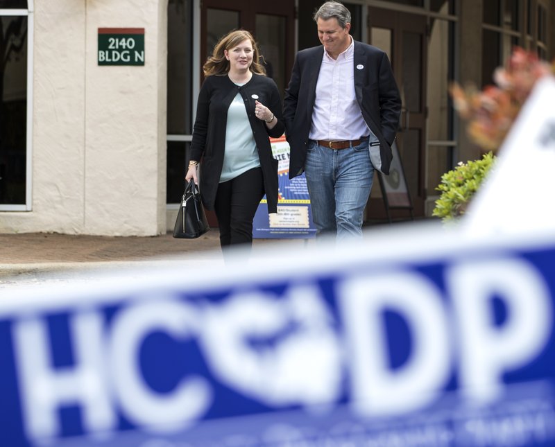 In this March 6, 2018, photo, Lizzie Pannill Fletcher and her husband, Scott Fletcher, walk out of the polling place at St. Anne's Catholic Church after voting in the primary election in Houston. Democrats are salivating at the prospect of flipping a wealthy Houston enclave that has been solidly Republican since sending George H.W. Bush to Congress in 1967 _ the kind of race they need to win for any hope of retaking the House in the 2018 midterm. But now that means navigating a potentially bruising intraparty battle of Democrats&#x2019; own making. The party&#x2019;s runoff underscores the lingering 2016 presidential primary rift between Bernie Sanders progressives and Hillary Clinton establishment. (Brett Coomer/Houston Chronicle via AP)