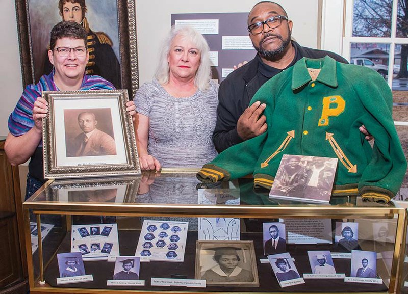 Members of the Pine Street Community Museum Planning Committee will present a program Thursday at the Historical Society of Faulkner County’s annual meeting. Many artifacts that will be in the future museum are now on display at the Faulkner County Museum. Making plans for Thursday’s meeting are Lynita Langley-
Ware, from left, director of the Faulkner County Museum, showing a photo of Dr. Ralph P. Cummins, one of the first African-American physicians in the community; Ree Walker, historical society board member; and Anthony Wayne Hoskins, chairman of the Pine Street Community Museum Planning Committee, showing his father’s letter jacket and a photo of Anthony’s parents, Sylvester and Gladys Hoskins.