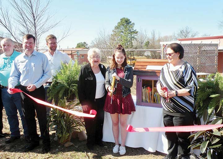 Bismarck Elementary School dedicated the Bismarck Little Free Library on March 2 in memory of the late Kim Bunn Hopkins, who was a retired teacher. Taking part in the ribbon-cutting ceremony are, from left, Hot Spring County Sheriff Mike Cash; Lance Howell, executive director, Malvern/Hot Spring County Chamber of Commerce; Gerald Black, 2016 president of the chamber board of directors; Jeane Bell, Hopkins’ mother; Faith Hopkins, Kim Hopkins’ daughter; and Pat Bunn, Hopkins’ aunt.