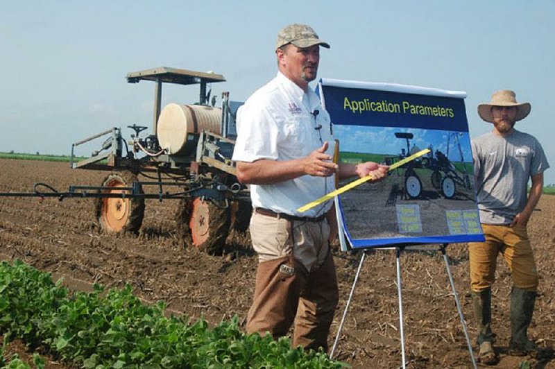 In this file photo Jason Norsworthy (left) is shown explaining the results of his experiments involving dicamba at the University of Arkansas Agriculture Division’s research station at Keiser in Mississippi County.

