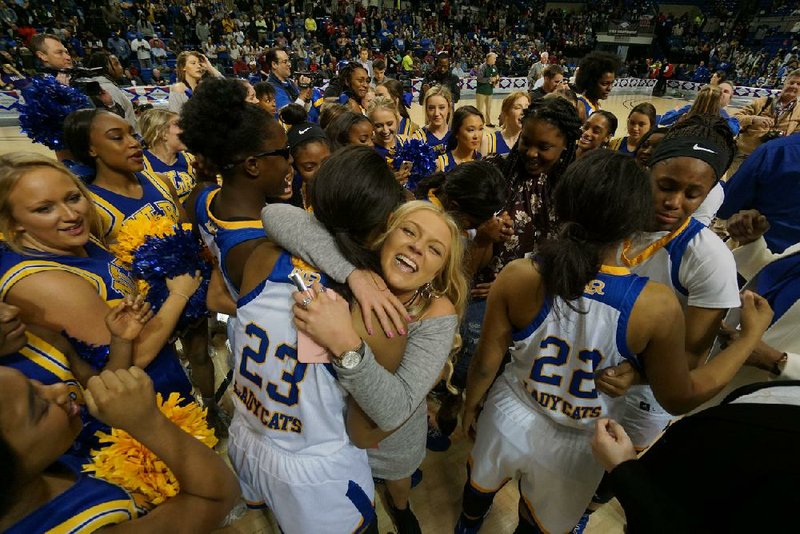 North Little Rock players are surrounded by cheerleaders Thursday while celebrating a 66-49 victory over Conway at Bank of the Ozarks Arena in Hot Springs. The Lady Charging Wildcats earned their fourth Class 7A girls state championship since 2006 and second in the past three years.