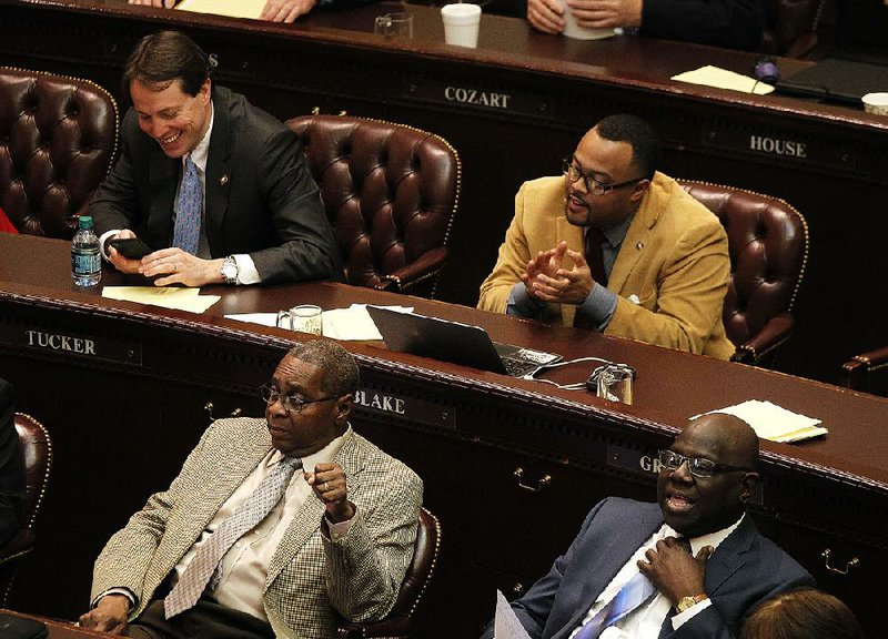 Rep. Charles Blake (top right) applauds passage of funding for the treasurer’s office Thursday after it was stripped of language allowing use of college-savings funds for elementary and high school expenses.