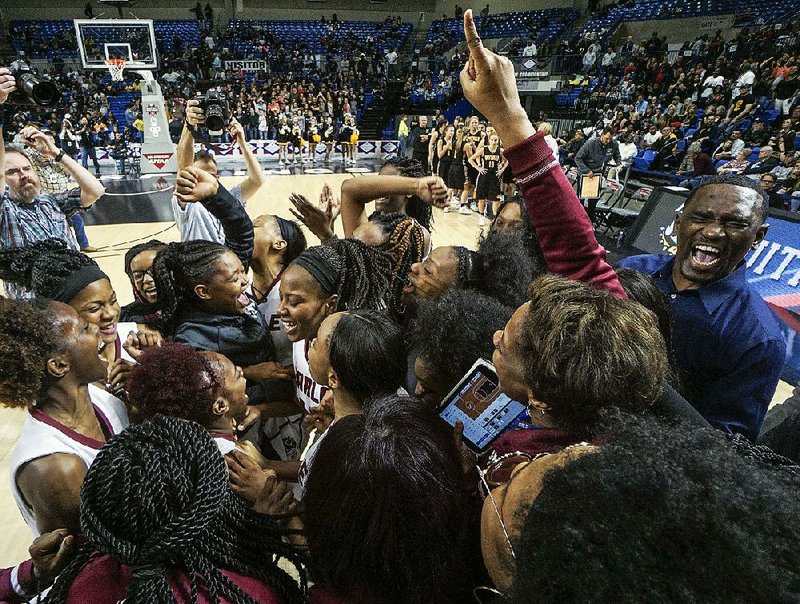 Earle celebrates after defeating Quitman 48-43 for the Girls 2A state championship Thursday at Bank of the Ozarks Arena in Hot Springs. The victory gave Earle its second state title in three years.