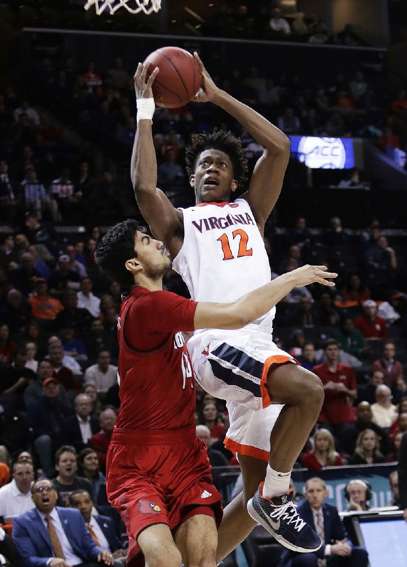 Virginia’s De’Andre Hunter (12) drives to the basket against Louisville’s Anas Mahmoud during the Cavaliers’ victory Thursday in the quarterfinals of the Atlantic Coast Conference Tournament. 