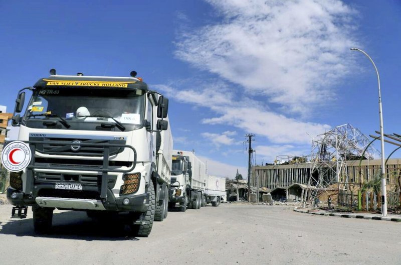 This photo released by the Syrian Red Crescent, show trucks convoy of the Syrian Red Crescent which carry humanitarian aid to be distributed in Douma, eastern Ghouta, a suburb of Damascus, Syria, Friday March 9, 2018. Relief workers used a brief lull in Damascus' embattled rebel-held suburbs to try and deliver remaining aid left over from a mission earlier in the week but were interrupted by renewed violence shorty after their team entered eastern Ghouta on Friday.(Syrian Red Crescent via AP)