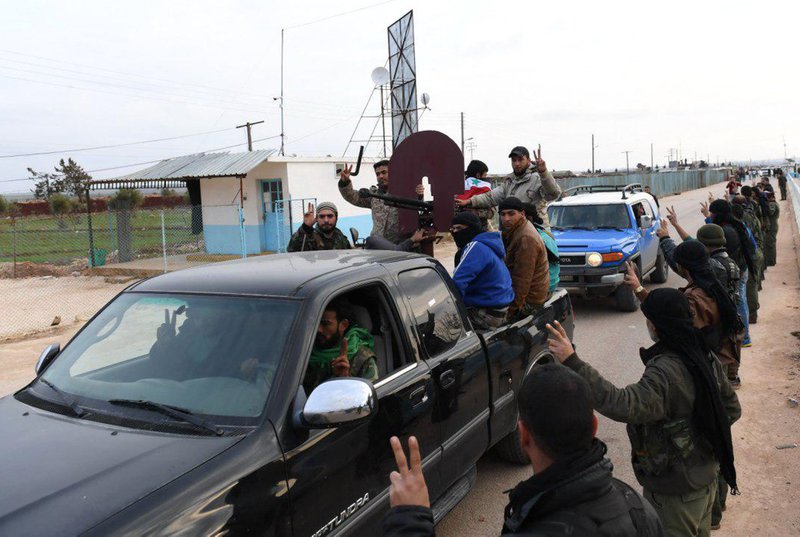 This photo released on February 21, 2018 by the Syrian official news agency SANA, shows Kurdish fighters, flashing the victory sign as they welcome militiamen loyal to the Syrian government, who are on their way to aid the Kurds against Turkish forces, in the northern city of Afrin, Syria. Turkey&#x2019;s shattering war on a Syrian Kurdish militia that is closely aligned with the United States is forcing the group to give up positions against Islamic State militants in the Syrian desert to defend against advancing Turkish troops. (SANA via AP)