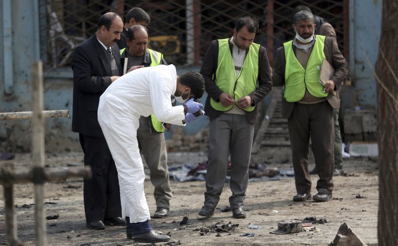 Security personnel inspect the site of a suicide attack in Kabul, Friday, March 9, 2018. A suicide bomber targeting Afghanistan's minority Hazaras blew himself up at a police checkpoint in western Kabul on Friday, killing nine people and wounding more than a dozen, officials said. (AP Photo/Massoud Hossaini)