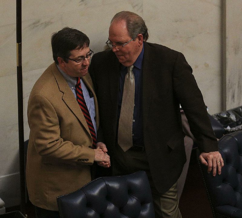 Sen. Larry Teague (left), D-Nashville, greets Sen. Terry Rice, R-Waldron, on the Senate floor Friday. Teague, co-chairman of the Joint Budget Committee, thanked his colleagues for their work after the Senate passed the final budget bill of the fiscal session.