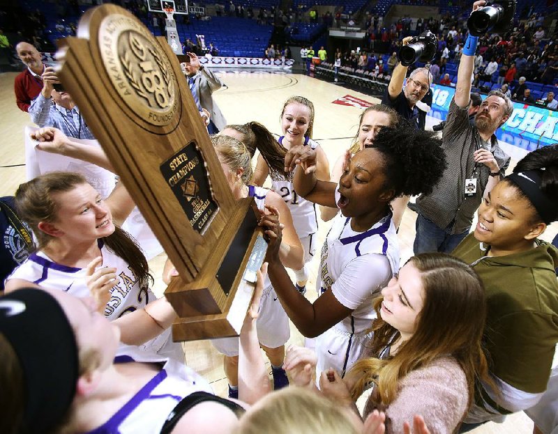 Central Arkansas Christian’s Christyn Williams (center) celebrates with her teammates after the Lady Mustangs’ 68-57 victory over Riverview in the Class 4A girls state championship Friday at Bank of the Ozarks Arena in Hot Springs.