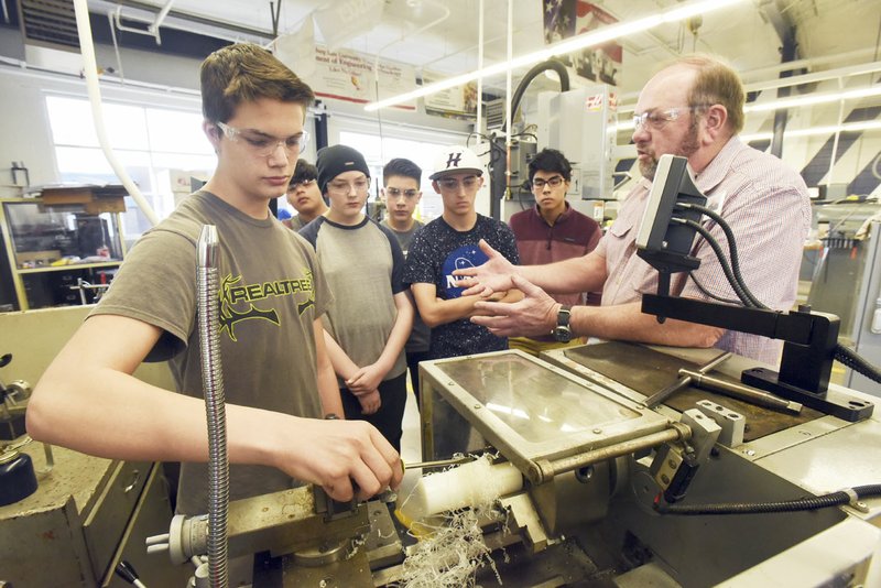 NWA Democrat-Gazette/FLIP PUTTHOFF Brandon Ford (left), a student at Heritage High School, works with teacher Barry Knight during precision machining class at the Rogers school.