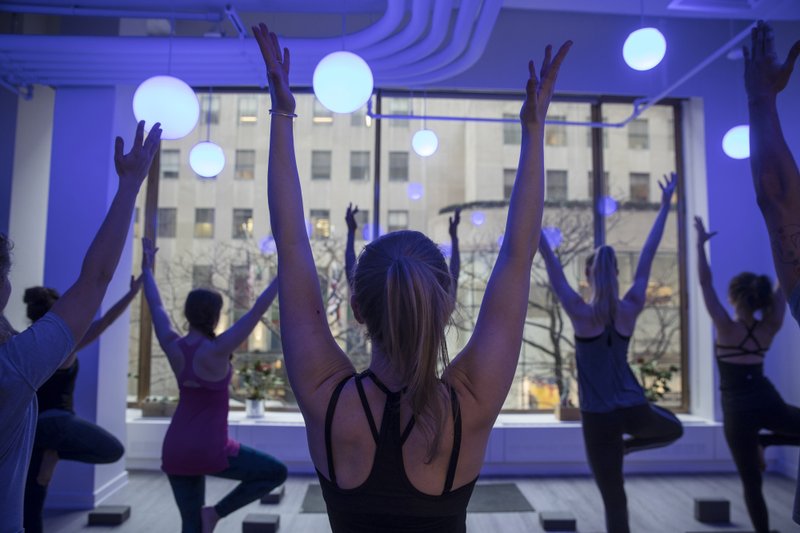 Customers take a yoga class offered by the Tishman Speyer Properties' Zo program and app at Rockefeller Center in New York on Feb. 26, 2018. MUST CREDIT: Victor J. Blue/Bloomberg