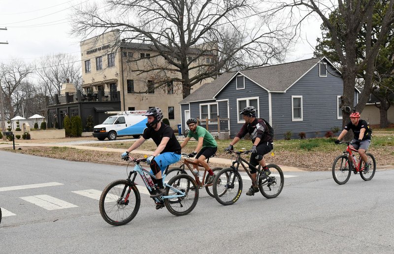 Riders pedal Saturday through Bentonville’s Market District.