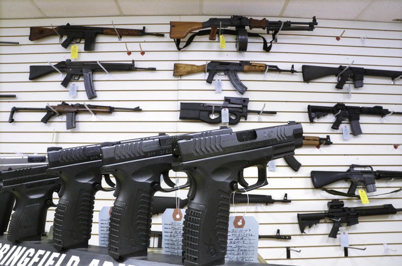FILE--In this Jan. 16, 2013, file photo, assault weapons and hand guns are seen for sale at Capitol City Arms Supply in Springfield, Ill. Recent mass shootings spurred Congress to try to improve the background check system used during gun purchases, but experts say the system is so fractured that federal legislation being considered in Washington D.C. will do little to help keep weapons out of the hands of dangerous people. (AP Photo/Seth Perlman, file)