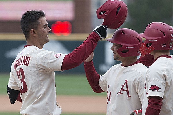 Arkansas first baseman Jordan McFarland (13) is congratulated by teammates after he hit a grand slam during a game against Kent State on Sunday, March 11, 2018, in Fayetteville. 