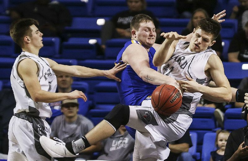 Guy-Perkins’ Wyatt Spires (center) and Izard County’s Justus Cooper (right) battle for a rebound during the Class 1A boys championship Saturday at Bank of the Ozarks Arena in Hot Springs. Spires scored 16 points as Guy-Perkins won 71-66.