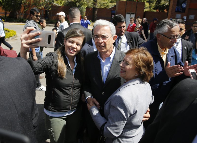 Colombia's former President Alvaro Uribe, who is running for Senator with the Democratic Center Party, poses for a selfie with supporters as he accompanies his party's presidential candidate Ivan Duque to a polling station during legislative elections in Bogota, Colombia, Sunday, March, 11, 2018. Colombia will hold presidential elections in May. (AP Photo/Fernando Vergara)