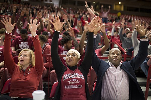 Arkansas Razorbacks head coach Mike Anderson (right) and his wife Marcheita Anderson (center) call the hogs during the NCAA selection show, Sunday, March 11, 2018 at Bud Walton Arena in Fayetteville. The Razorbacks will play Butler in Detroit on Friday